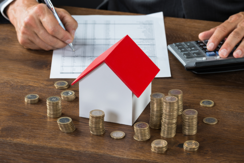 một bàn tay cầm bút, một bàn tay bấm máy tính