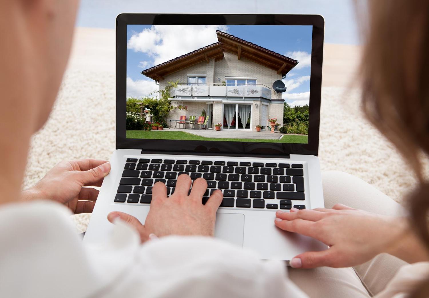 Hình ảnh 2 ngồi xem hình ảnh ngôi nhà trên chiếc máy tính xách tay