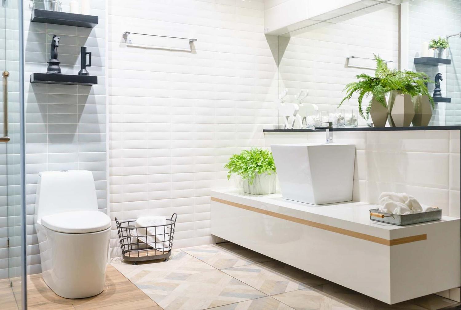 Một vài chậu cây xanh đặt trong nhà vệ sinh màu trắng để hóa giải phong thủy.