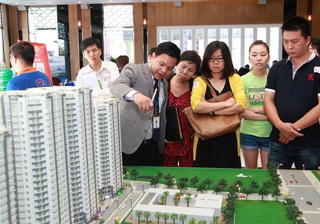 môi giới đang giới thiệu về khu chung cư thông qua mô hình cho khách hàng