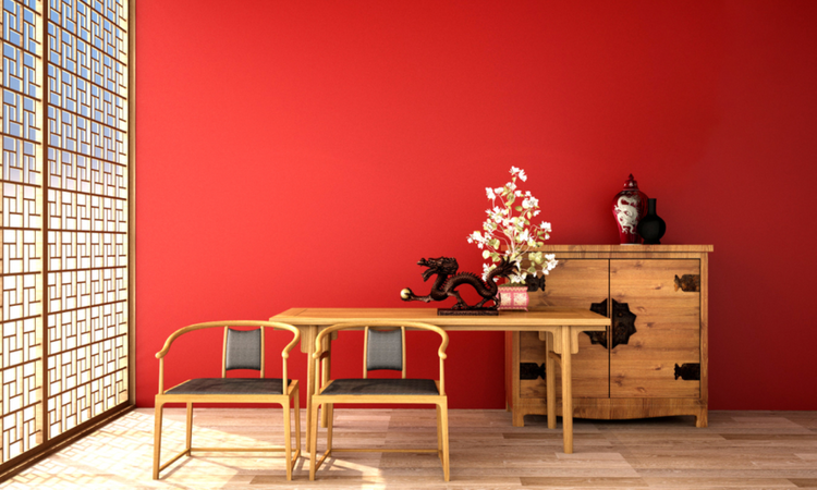 Ảnh chụp căn phòng kiểu Trung Quốc, bức tường màu đỏ, kệ gỗ, bàn ghế.