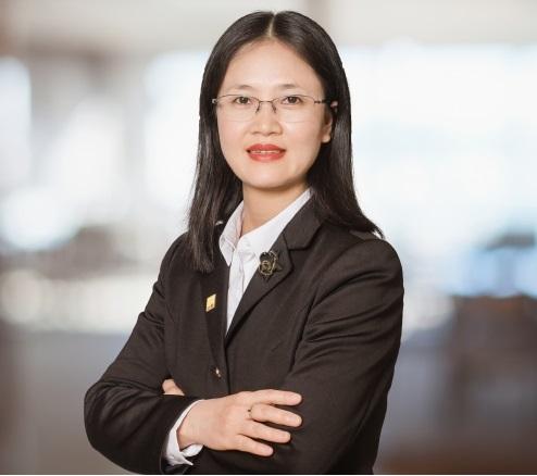Chân dung một phụ nữ mặc vest đen, đeo kính.