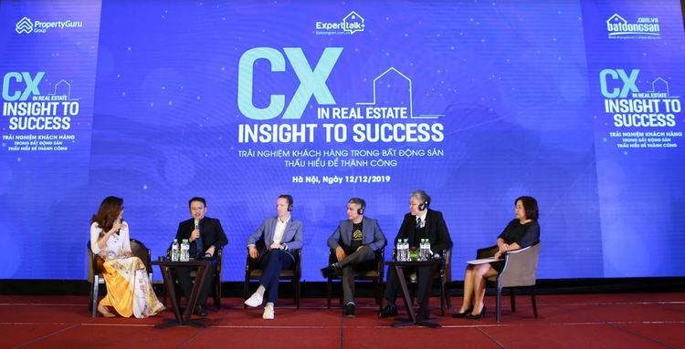 6 người ngồi trên sân khấu, 1 chiếc bàn, thảm sân khấu màu đỏ