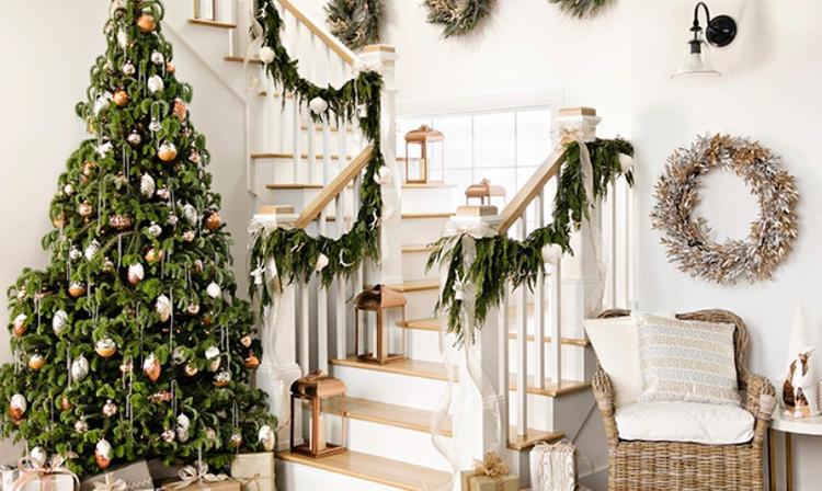 cầu thang được trang trí bằng dây thông tươi, bên cạnh là cây thông Noel