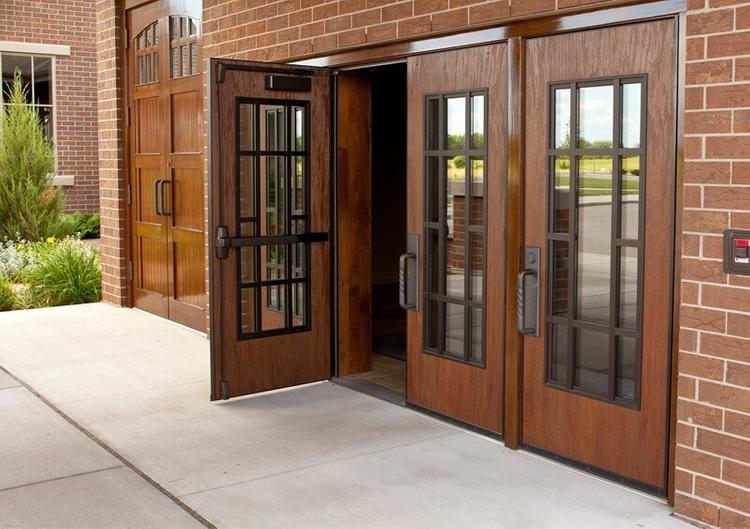 Cửa ra vào một ngôi nhà làm bằng gỗ và kính màu nâu.