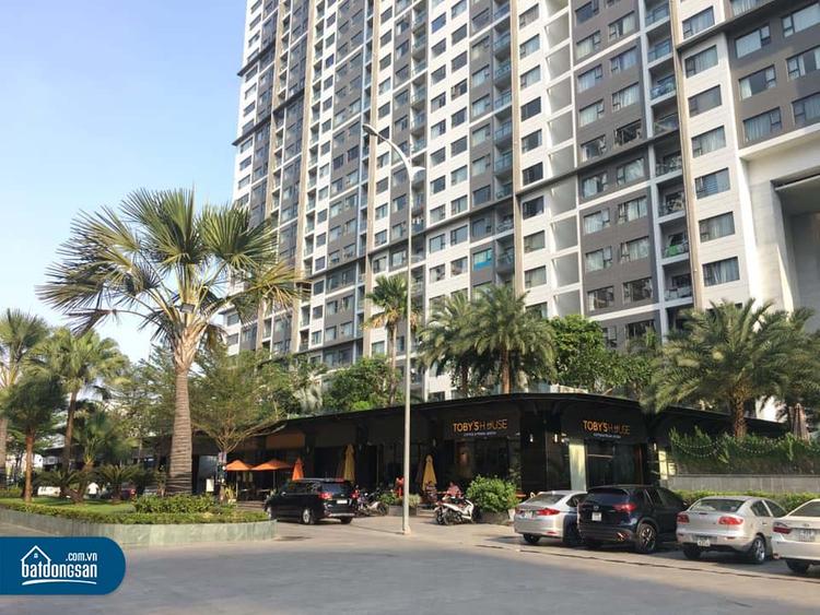 Ảnh chụp từ dưới lên một dự án chung cư tại TP.HCM, bên dưới là đường, cây xanh, ô tô.