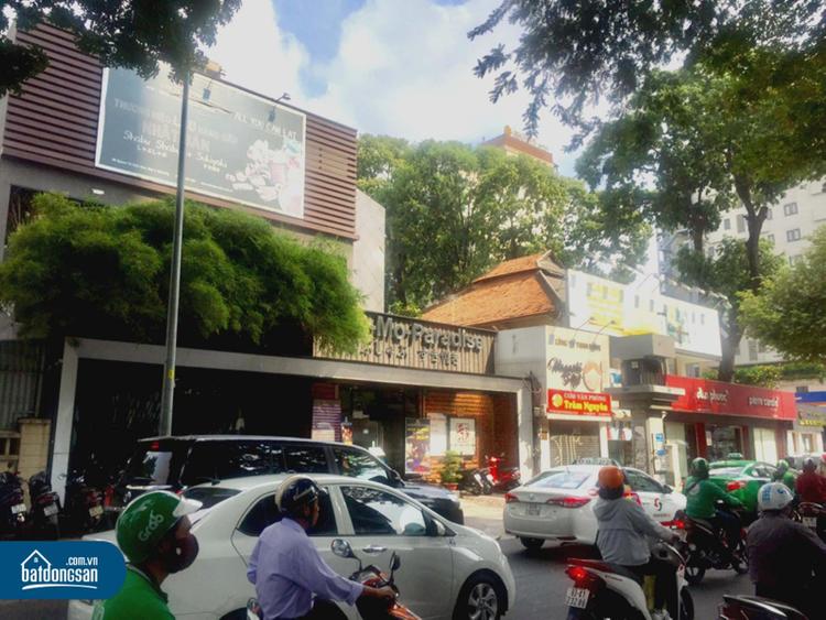 Nhiều xe máy, ô tô, người qua lại trên một tuyến đường cạnh dãy nhà mặt phố.