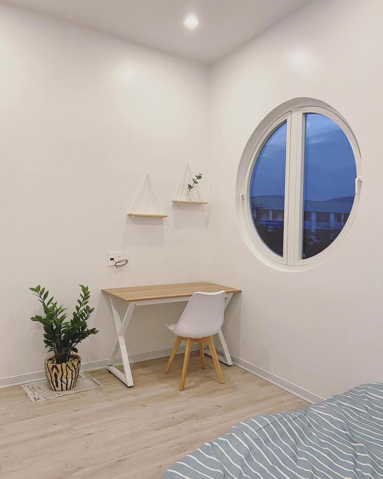 Góc làm việc, học tập được bố trí cạnh cửa sổ khung tròn xinh xắn.