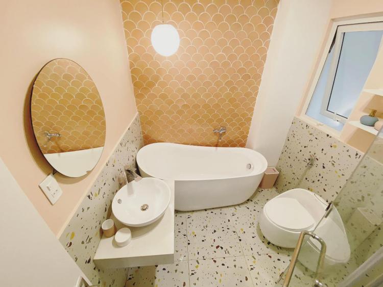 Phòng tắm ấn tượng với tường ốp gạch mosaic vảy cá màu hồng cam nổi bật.
