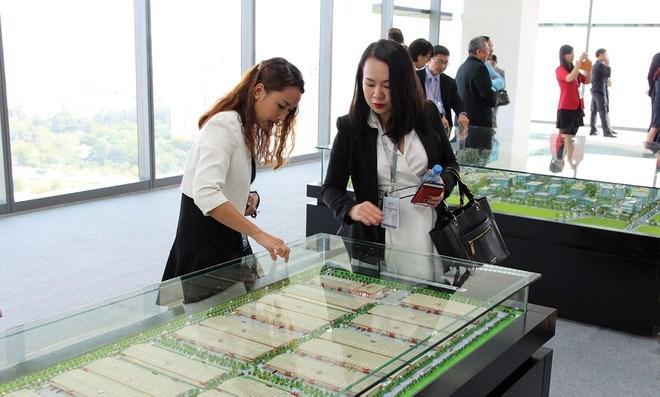 hai người đang đứng trao đổi về mô hình khu đất công nghiệp