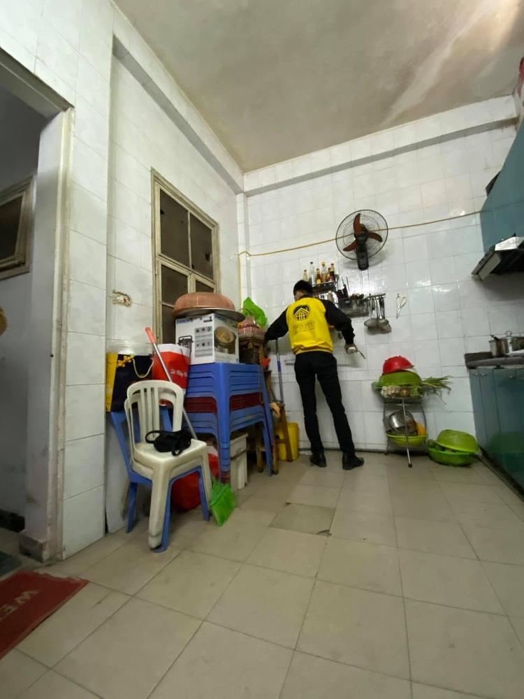 người đàn ông đang đứng trong căn phòng nhiều đồ đạc