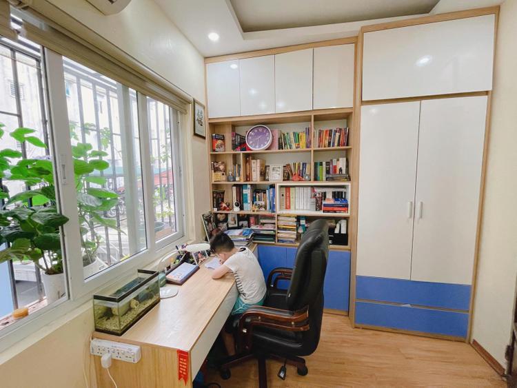 bé trai đang ngồi ở bàn cạnh cửa sổ