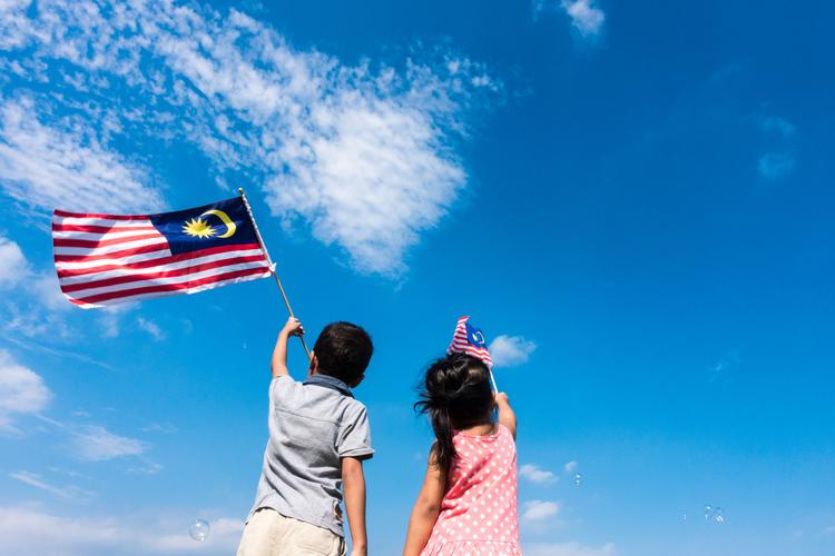 Unknown kids/brother and sister waving the Malaysia Flag. Indepe