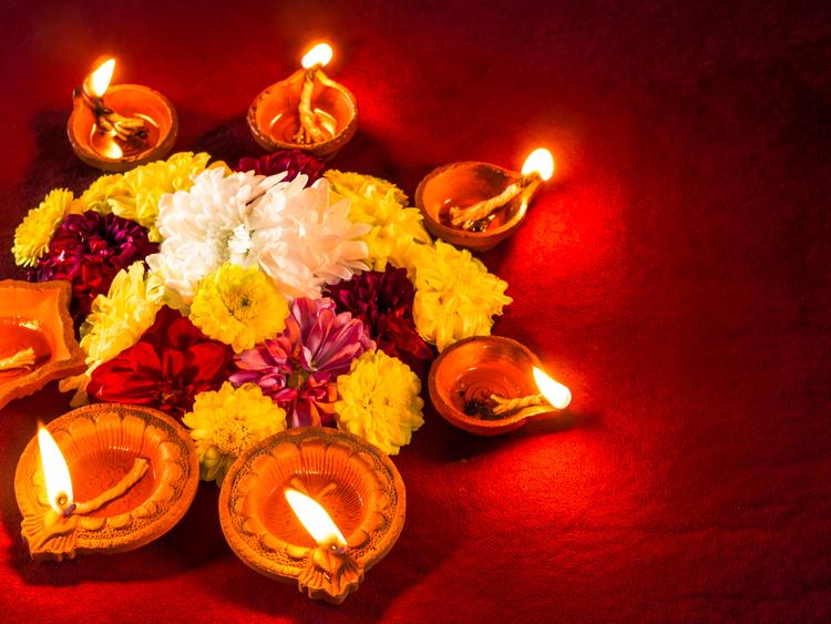 Traditional clay diya lamps lit with flowers for Diwali festival celebration.