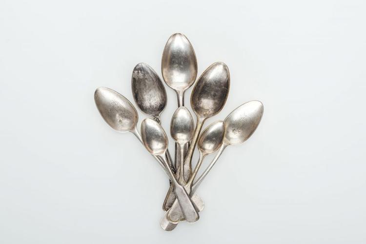 top view of shiny vintage silver empty spoons on white background