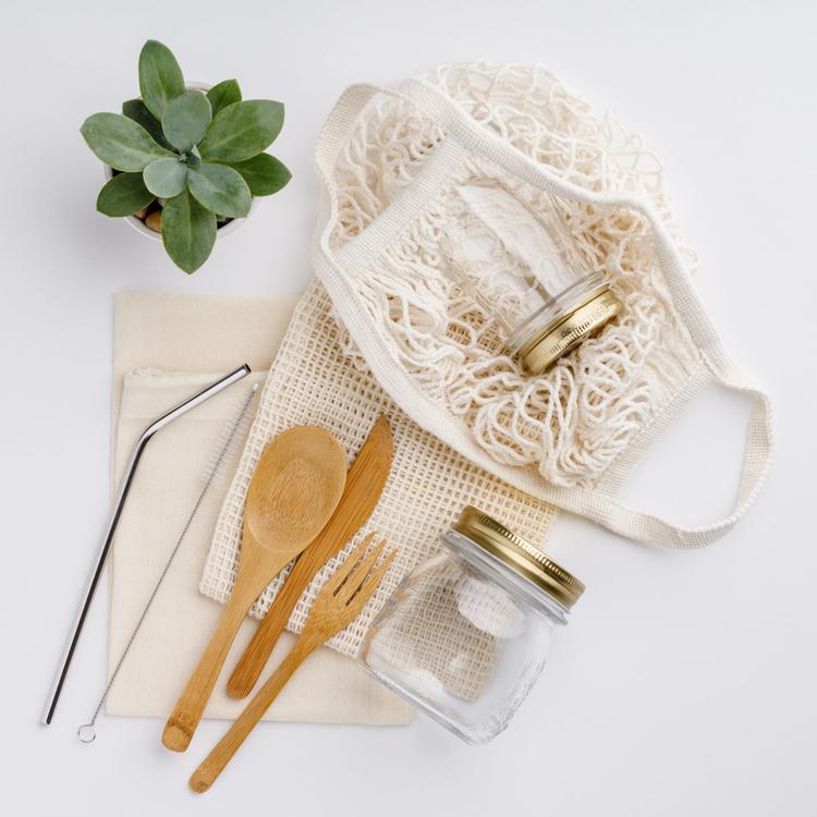 Natural color eco bags, reusable metal and bamboo straws, glass jars, wooden knifes and forks, zero waste cleaning and beauty products