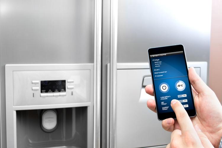 Man uses his smartphone to set up the fridge