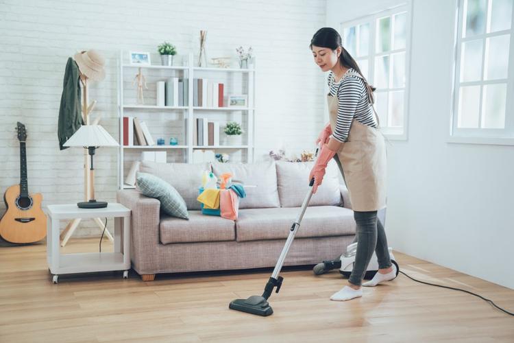 young housewife using vacuum cleaner