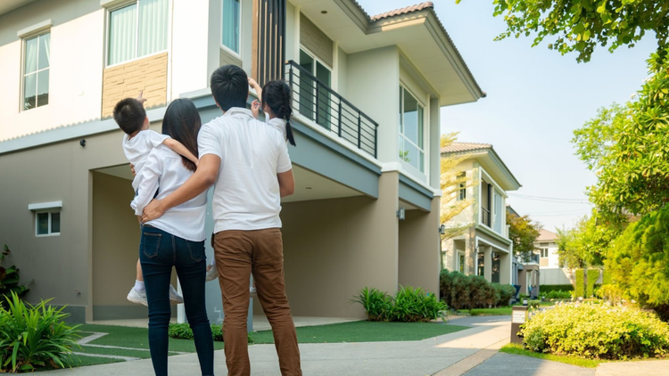 Young parents with their son and daughter are admiring their new home