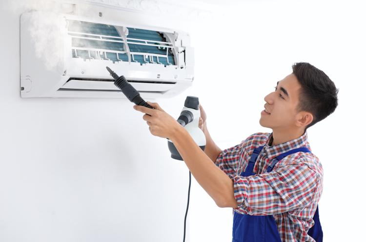 technician-cleaning-air-conditioner-after-house-renovation