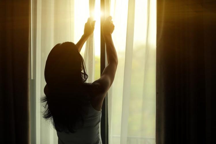 woman and curtain against sun