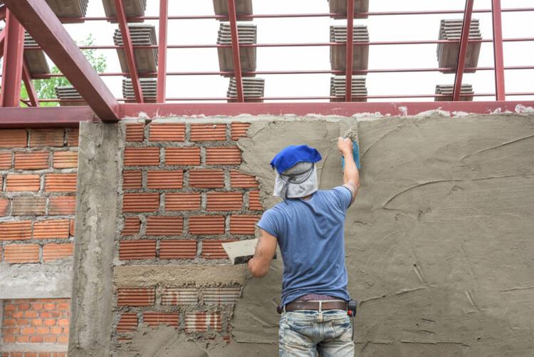 worker-plastering-concrete-at-wall