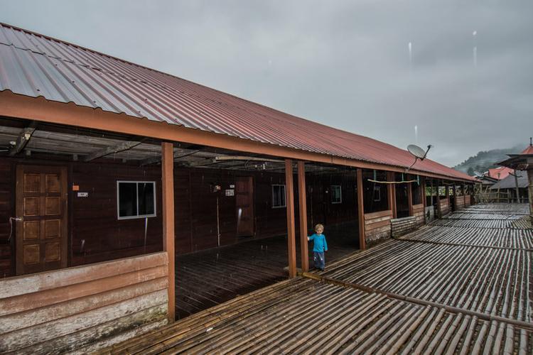 Longhouse with a boy standing at the entrance