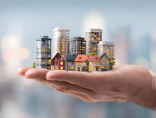 Close-up of a palm holding miniature house and building models