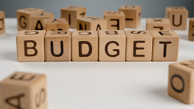 Wooden blocks spelling out "BUDGET" on a white surface