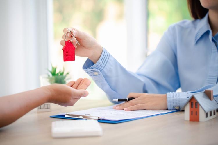 A landlord handing over her house keys to a new tenant