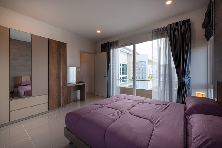 A modern bedroom features a purple duvet bed