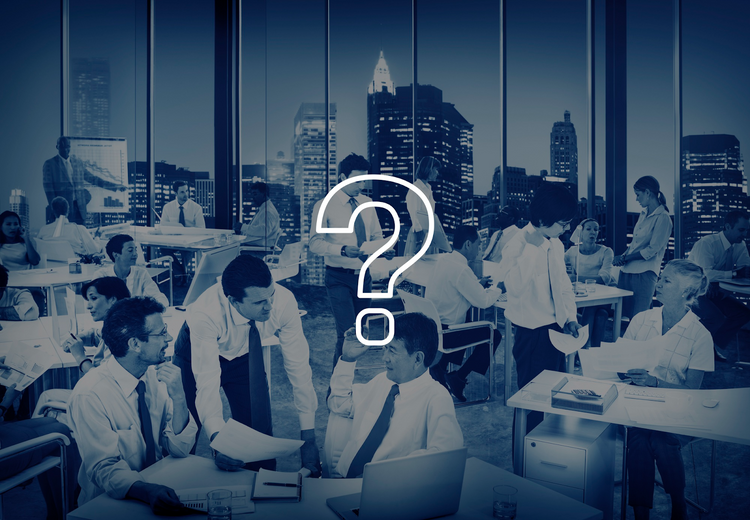 Question mark overlaid on a busy, dimly lit office with workers.