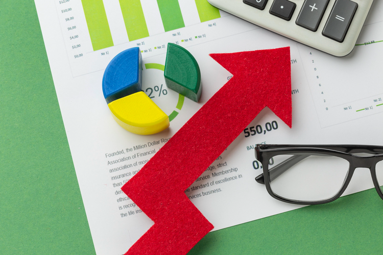 Close-up of a red upward-trending arrow placed on business documents