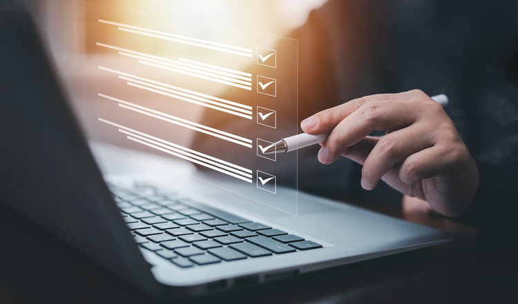 Close-up of a hand holding a stylus and checking off a digital checklist