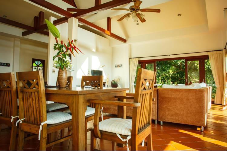 A warm dining interior featuring a wooden dining table and chairs, and soft lighting, creating a warm and inviting space.