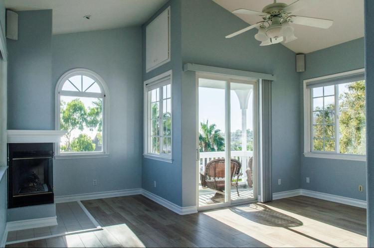 Trendy modern interior of a living room with blue walls and white windows