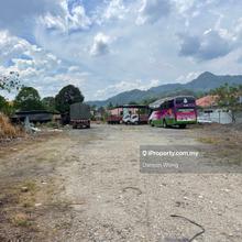 Empty land surrounded by shops and houses.